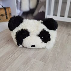 a stuffed panda bear laying on the floor