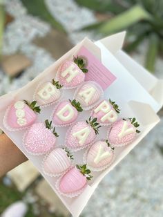 a person holding a box of chocolate covered strawberries with the words happy birthday written on them