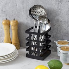 a kitchen utensil holder with spoons and spatulas sitting on top of it