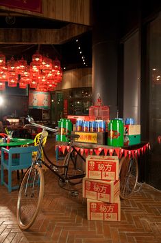 a bicycle parked in front of a table filled with drinks