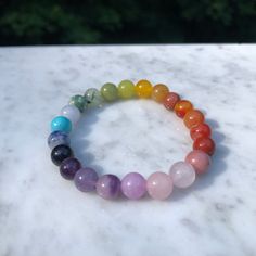 Introducing our exquisite handmade Rainbow Chakra 🌈Gemstone bracelet. This stunning design features a combination of: ❤️Red Jasper, Banded Carnelian, Red Aventurine 🧡Orange dyed Chalcedony, Goldstone 💛Yellow Aventurine, Yellow Jade, Lemon Jade  💚Green Jade, Prehnite, Green Spot Jasper 💙Aquamarine, Blue Magnesite, Blue Goldstone  💜Amethyst, Lavendar Chalcedony, Lepidolite Kunzite, Rose Quartz, and Rhodonite Beads are approximately 8mm each but vary a little in size. Bracelet is with a non-e Rainbow Crystal Bracelet With Natural Stone Round Beads, Rainbow Crystal Bracelet With Gemstone Round Beads, Rainbow Crystal Bracelet With Natural Stones, Rainbow Crystal Bracelet With Natural Stones And Round Beads, Rainbow Crystal Bracelet With Round Gemstone Beads, Multicolor Round Beaded Bracelets For Healing, Spiritual Multicolor Round Crystal Bracelet, Spiritual Multicolor Crystal Bracelet, Rainbow 8mm Beads Jewelry For Meditation