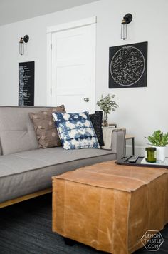 a living room with a couch, coffee table and pictures on the wall above it