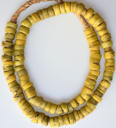 Smaller sized antique yellow Hebron Beads. Some chips and pitting on these old beads. Multiple strands available, all similar to the one pictured. Length of strand: 24 inches including raffia, ~21 inches of beads; Average Diameter size: 10-12mm Date: 1800's These were collected by us in the 1970s - 1980s. Antique Round Spacer Beads, Yellow Wooden Beads For Jewelry Making, Antique Oval Beads, Artisan Yellow Beaded Necklace With Wooden Beads, Yellow Wooden Beaded Necklaces For Beach, Bohemian Rondelle Large Beads, Rustic Hand-strung Beaded Necklace With Round Beads, Yellow Wooden Beads Necklace For Beach, Amber Bohemian Spacer Beads