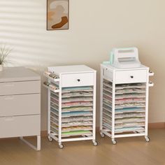 two white filing cabinets sitting next to each other on top of a hard wood floor