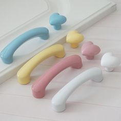 four different colored handles on a white counter top next to a sink and mirror with the words miffy's written above it