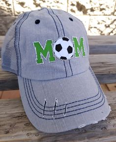 Mom Bling Trucker Cap, Soccer Mom Women's Trucker Hat, Distressed Soccer Hat, Bling Soccer Hat Many hat colors to choose from, you choose team colors and personalization for hat. This design can be done for any sport! Listing pictures are of a slightly distressed grey denim washed trucker cap with light grey stitching and light grey mesh back and adjustable strap with pony tail opening. MOM is on front in green with a rhinestone soccer ball YOU CAN ADD ADDITIONAL NAME or NUMBER PERSONALIZATION- Gray Distressed Hat, One Size Fits Most, Trucker Baseball Cap With Brim, Trucker Style Brimmed Baseball Cap, Adjustable Distressed Trucker Hat For Baseball Season, One Size Fits Most Trucker Baseball Cap, Distressed Green Cap Hat, Green Distressed Cap, Adjustable Fun Hats For Sports Events, Distressed Green Cap