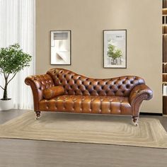 a brown leather couch sitting on top of a wooden floor next to a white rug