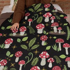 a woman sitting on top of a bed covered in mushrooms