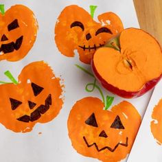 apples and oranges with faces drawn on them sitting next to each other in front of a piece of paper