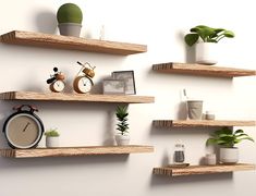 three wooden shelves with plants, clocks and other items on them against a white wall