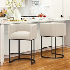 two white chairs sitting on top of a kitchen counter