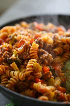 a skillet filled with pasta and meat