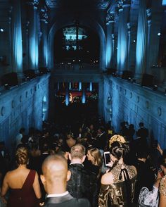 a large group of people standing in a room with blue lights on the walls and ceiling