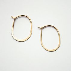 "These uniquely oval shaped hoop earrings are lightly hammered into shape. They have an interlocking closure, that keep them on securely. I hammer each one of these earrings into shape and forge them by hand in my studio, adding a nice shimmer when they hit the light. Very lightweight hoops are great for everyday wear. The part of the earring that slides through the earlobe is slightly thinner then the rest of the hoop, for a very comfortable fit.  MEASUREMENTS:  length 1\" width 3/4\" *READY to SHIP* MADE BY HAND JEWELRY SARAHHEALYDESIGN.COM Made in the U.S.A." Modern Oval Hoop Earrings With Ear Wire, Minimalist Oval Everyday Earrings, Nickel-free Oval Hoop Earrings For Everyday, Oval Nickel-free Hoop Earrings For Everyday Wear, Minimalist Handmade Oval Hoop Earrings, Everyday Oval Nickel-free Hoop Earrings, Simple Oval Everyday Jewelry, Simple Everyday Oval Jewelry, Handmade Oval Gold Hoop Earrings