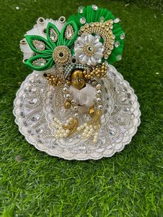 an ornate glass dish with beads and flowers on it in the grass, sitting on top of a green lawn