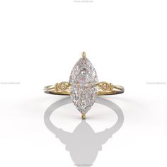 a yellow gold ring with a pear shaped diamond