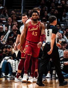 the basketball player is standing on the court with his arm around another player's head