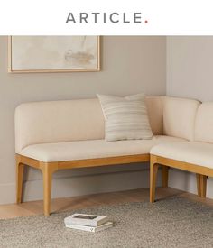 a white couch sitting on top of a hard wood floor next to a book shelf