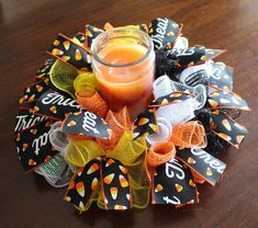 an orange candle sitting on top of a halloween wreath