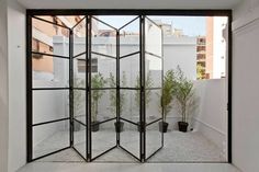 a room divider in the middle of a courtyard with potted plants on it