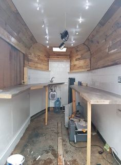 the inside of a building that is being remodeled with wood paneling and exposed lighting