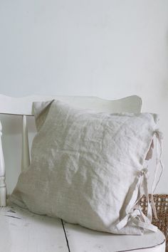 a white chair sitting next to a pillow on top of a table