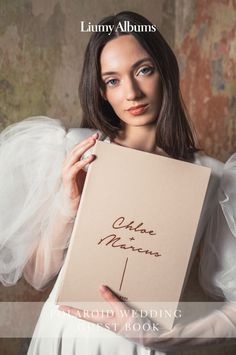 a woman is holding up a sign that says, wedding guest book on the cover