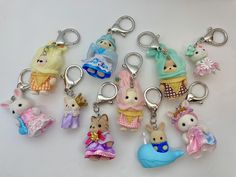 a bunch of key chains that are shaped like animals and have different outfits on them