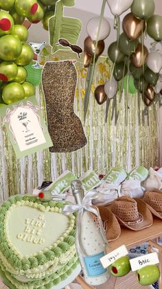 a table topped with lots of cakes and balloons