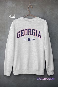 Vintage Style Georgia Unisex Crewneck Sweatshirt Perfect for any situation, these heavy blend crewneck sweatshirts are pure comfort. Made from a polyester and cotton combination which helps designs come out looking fresh and beautiful. The collar is ribbed knit, so it retains its shape even after washing. There are no itchy side seams on these sweaters. SIZING: Sweatshirts are unisex regular fit. Pick your usual size for a normal fit or size up for a more relaxed feel. Please check size chart for exact dimensions. PRODUCT DETAILS: -DTG printed using water based eco-friendly inks for a very soft feel that won't peel off or fade after washing. NO VINYLS OR PLASTIC STICKERS USED. -GILDAN Heavy Blend™ Sweatshirt -Medium-heavy fabric (8.0 oz/yd² (271 g/m²) -50% pre-shrunk cotton, 50% polyester Collegiate Crew Sweatshirt Pre-shrunk, Collegiate Crew Sweatshirt, Pre-shrunk, Team Spirit Crew Neck Sweatshirt In Athletic Heather, Collegiate Crew Neck Sweatshirt In Athletic Heather, Athletic Heather Crew Neck Sweatshirt For Fan Gear, College Athletic Heather Sweatshirt For Sports Season, Athletic Heather Sweatshirt For College Sports Season, Athletic Heather Crew Neck Fan Apparel Sweatshirt, Gray Long Sleeve Team Name Sweatshirt