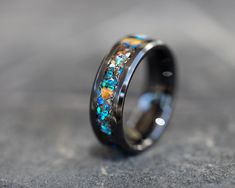 a wedding ring with blue and yellow flowers inlayed to the inside of it