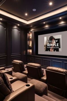 a home theater with leather recliners in front of a large screen and black walls