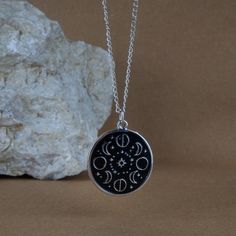 Introducing the stunning Moon Phases Necklace, a beautiful accessory that will have you feeling connected to the cosmos! This necklace features a black and silver color scheme, and has intricate moon phase signs on it, so you can wear the beauty of the lunar cycle close to your heart. Not only is this necklace a stylish addition to any outfit, but it also holds spiritual significance. The different phases of the moon represent different stages of growth and change in our lives. The full moon symbolizes completion and fruition, while the new moon represents new beginnings and fresh starts. Wearing this necklace can serve as a reminder to embrace the cycles of life and to trust the process of growth and transformation. The black pendant background of the moon cycle signs on this necklace add Taurus Sun Scorpio Moon, Different Phases Of The Moon, Taurus Sun, Stages Of Growth, Moon Phase Jewelry, Lunar Magic, Moon Phases Art, Silver Color Scheme, Moon Necklace Silver