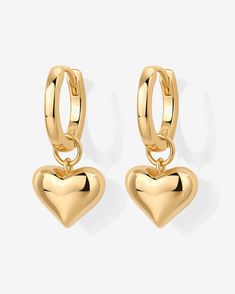 Description:Make a bold fashion statement with our stunning heart huggie earrings, perfect for adding a touch of romance to your everyday look. Small but mighty, featuring a charming heart charm, they're ideal for any occasion, from a Valentine's Day date to a cozy evening.Materials: 14K Yellow Gold or Rhodium plated. Sterling silver posts. Heart charm dimensions: 8.4mm x 10mm. Hoop diameter: 12mm Hypoallergenic, nickel free, and lead-free.