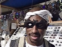 a man wearing a blindfold standing in front of a store