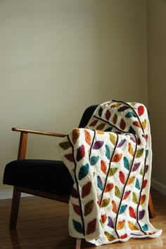 a crocheted blanket sitting on top of a wooden chair