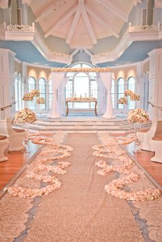 the aisle is decorated with pink flowers and white draping for an elegant wedding