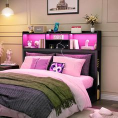 a bed with pink and green comforters in a bedroom next to a book shelf