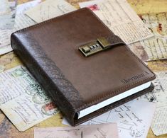 a brown leather journal with a lock on top of some old envelopes and letters