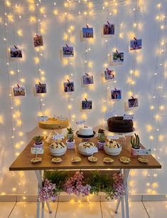 a table topped with cakes and desserts under string lights