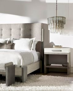 a bedroom with a bed, nightstand and chandelier