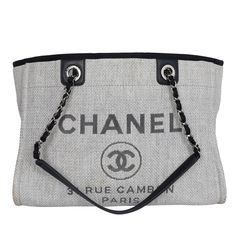 Authentic, pre-owned Chanel Deauville Grey tote large bag. Features silver-tone hardware, black leather trim, dual shoulder straps with chain-link and leather trim, dual handles, gray embroidered logo embellishment at front face, tonal canvas lining, three pockets on interior walls; one with zip closure and magnetic snap closure at top. Strap drop: 11.5" Authenticity hologram stamp and card read: 22060906 Made in Italy 2017 Chanel Canvas, Canvas Leather Tote, Leather Formal Shoes, Leather Detailing, Grey Tote, Front Face, Chanel Deauville Tote Bag, Bag Packaging, Large Bag