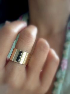 a close up of a person wearing a gold ring