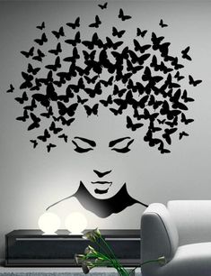 a living room with a white couch and black butterflies on the wall