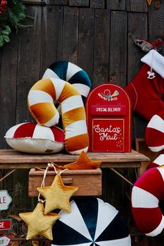 christmas decorations on display in front of a wooden fence with santa's hat and candy canes