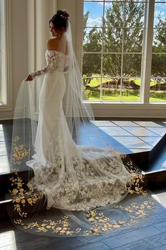 a woman in a wedding dress is standing on the floor with her veil over her head