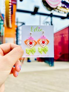 a person holding up a card with clown earrings on it's ear and the caption, effic