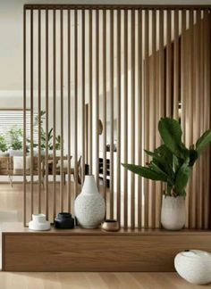 a living room with wooden slats and white vases