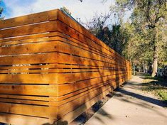 a wooden fence is lined up along the sidewalk