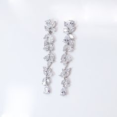 These Beautiful Romantic FLOWER DANGLE CRYSTAL BRIDAL EARRINGS are made of very fine quality of AAA+ CZ crystals AND PLATED WITH WHITE GOLD for your special day! Simulated diamonds are also known as diamond simulants and include things like cubic zirconia (CZ), moissanite, and YAG. They can also include some natural clear gemstones like white sapphire, white zircon or even clear quartz. Simulated "diamonds" can be gorgeous but do not possess the chemical and physical properties of actual diamond Diamond Earrings Long, Bridal Earrings Statement, Clear Gemstones, Bridal Dangle Earrings, Crystal Bridal Earrings, Physical Properties, Crystal Diamond, Romantic Flowers, Jewelry Bridal